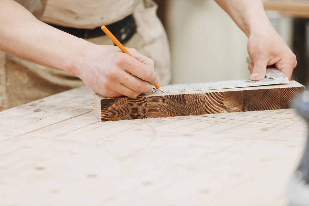 Carpenter,Marking,A,Measurement,On,A,Wooden,Plank.,Working,Weekdays